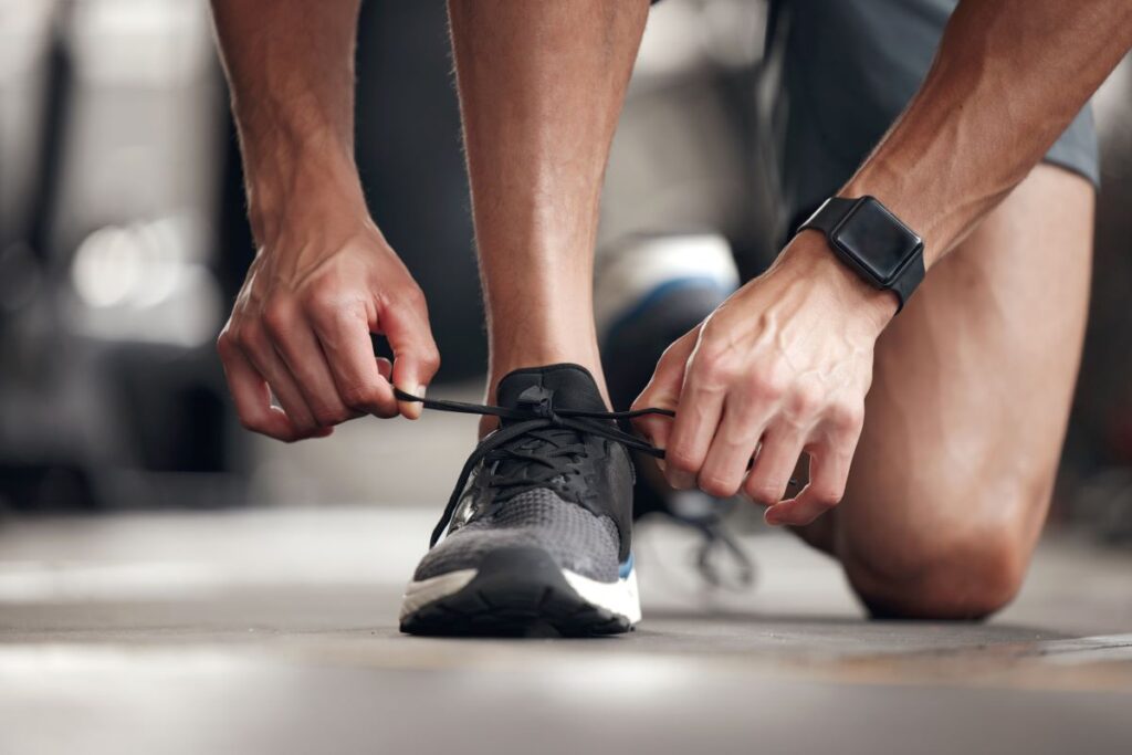 man tieing shoe for physical safety for his feet man tieing shoe for physical safety for his feet